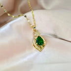 Halsband med grön sten i bladhänge i två designer i guldfärg