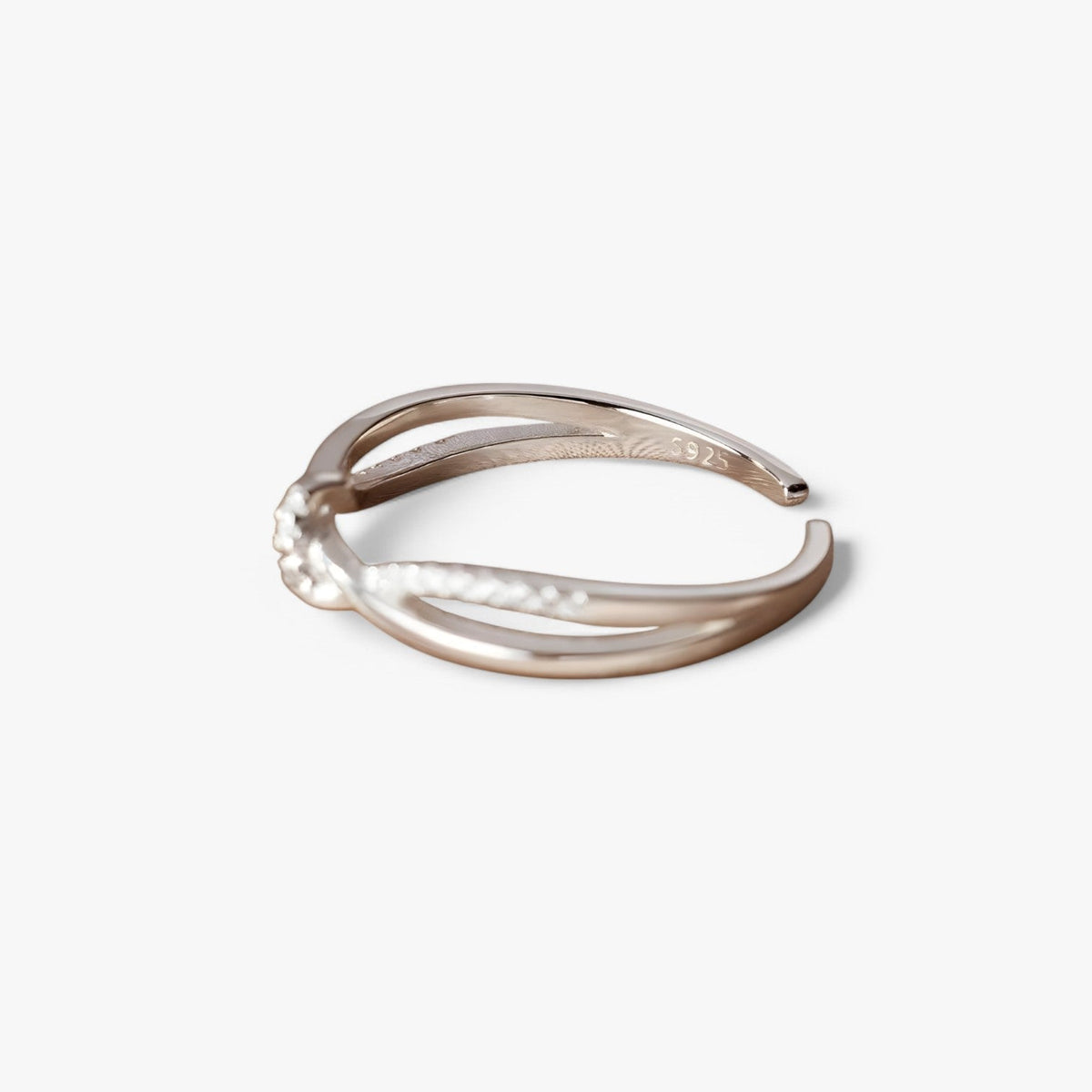 Silverfärgad ring med knut- och korsdesign och zirkoniastenar