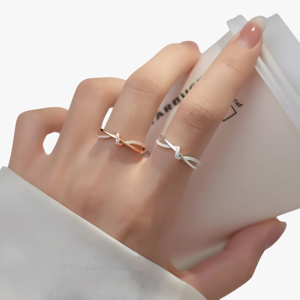 Silverfärgad ring med knut- och korsdesign och zirkoniastenar