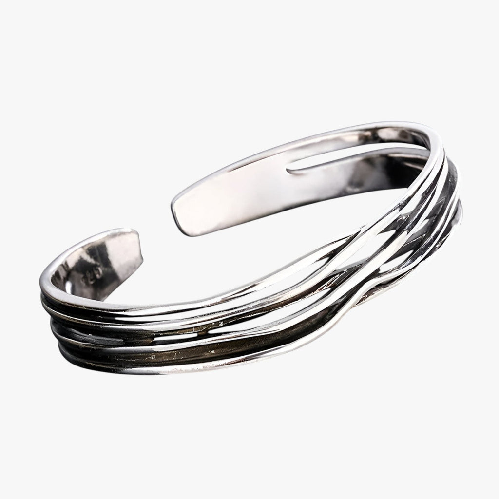 Pulsera trenzada en tono plateado con detalle tejido en la muñeca