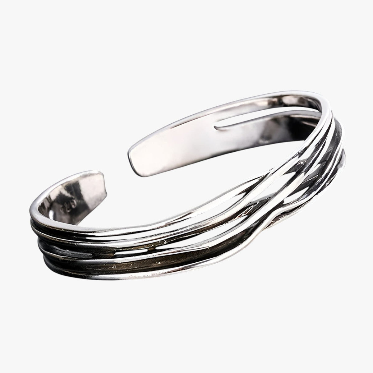 Pulsera trenzada en tono plateado con detalle tejido en la muñeca