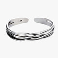 Pulsera trenzada en tono plateado con detalle tejido en la muñeca
