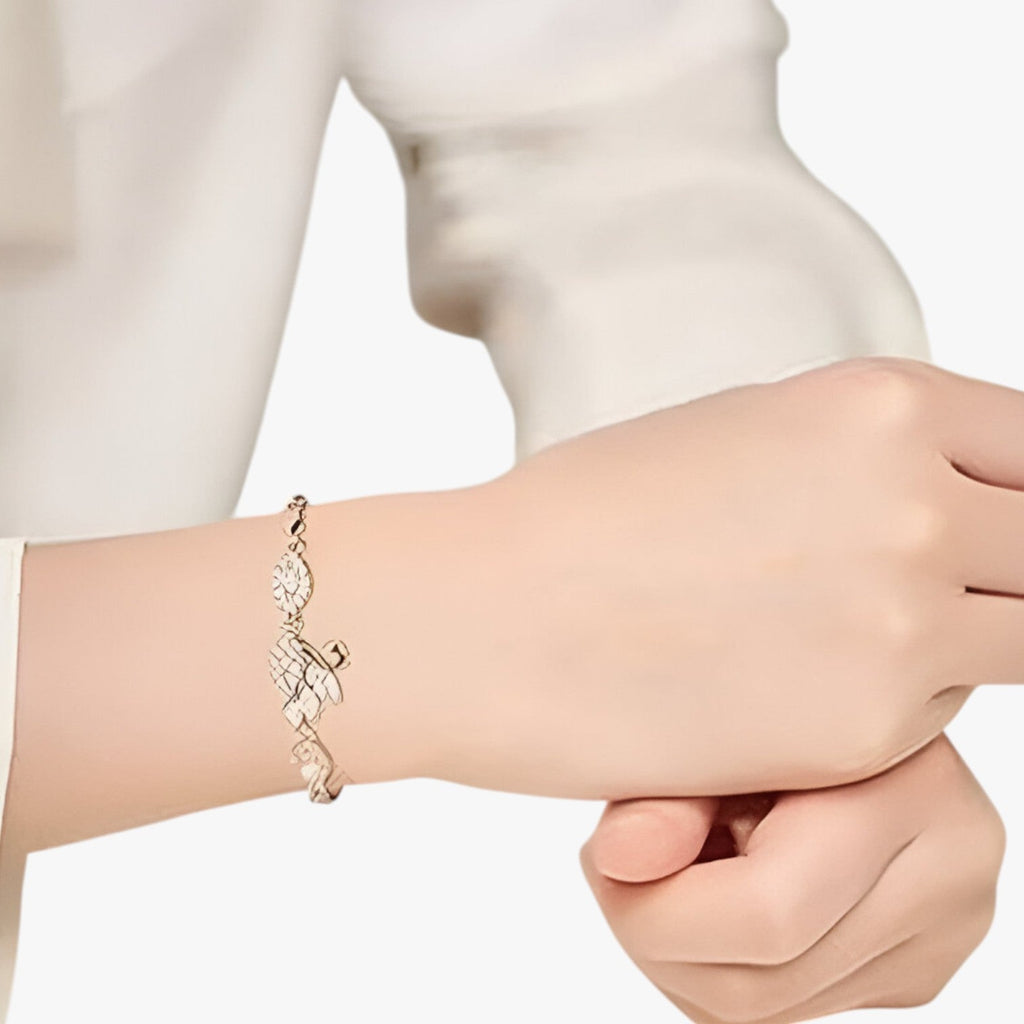 Armband i guldton med svanmotiv och glittrande zirkondetaljer