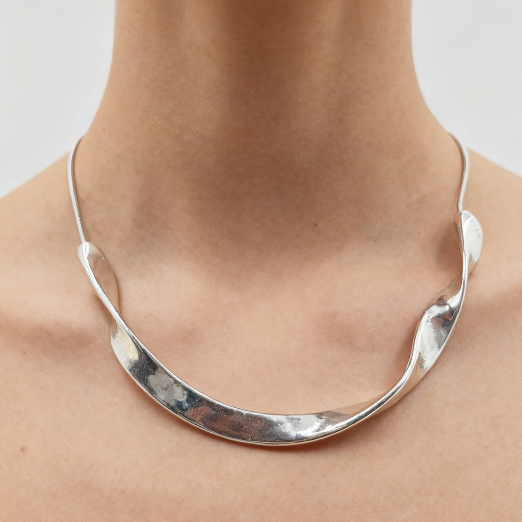 Skulpturalt polerat vintagekragehalsband i silverfärg