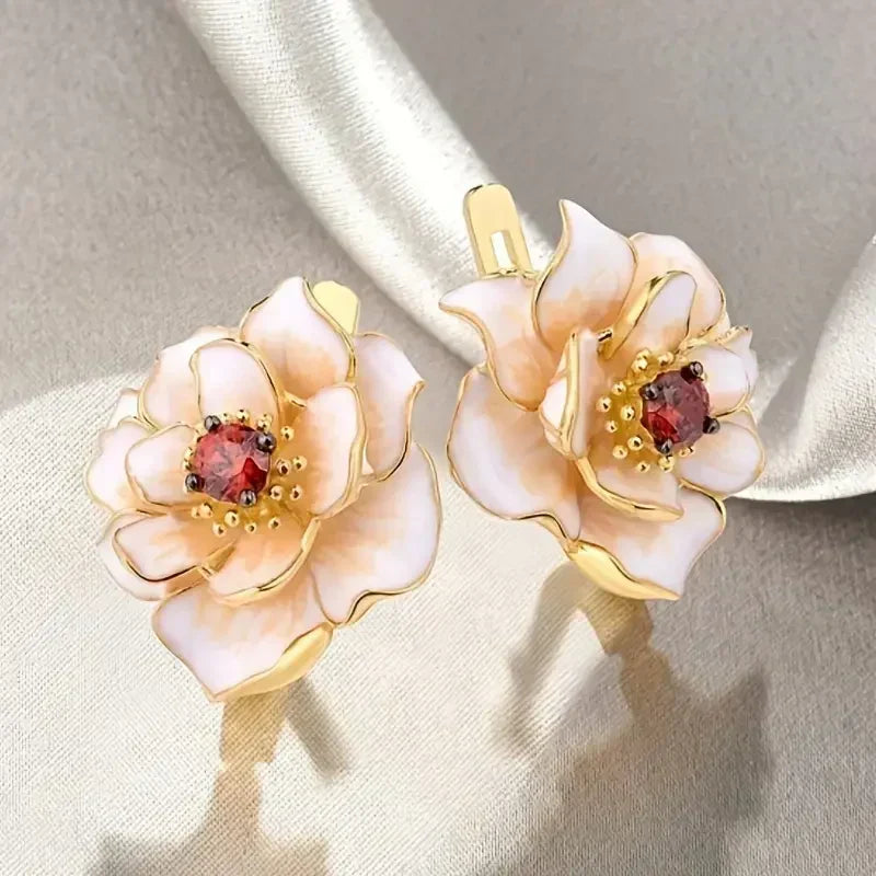 Pendientes de flor blanca con circonita roja en color oro