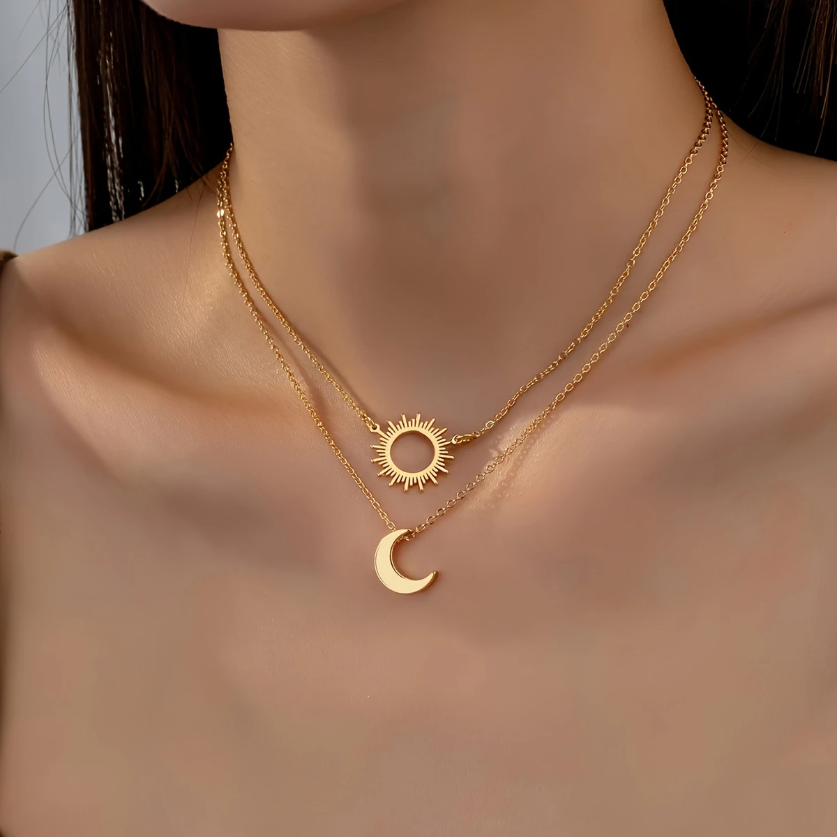 Flerlagrat halsband med sol och måne i guldfärg och himmelsk charm