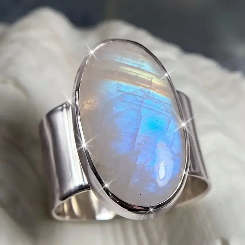 Ring med oval mjölkvit sten och mjukt sken, silverfärgad