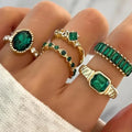 Ringset med gröna stenar i oval och rad